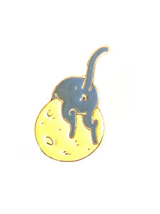 gray cat laying over a yellow moon enamel pin