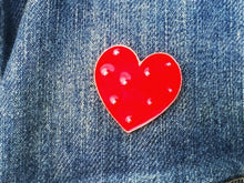 closeup view of heart pin on a jean jacket