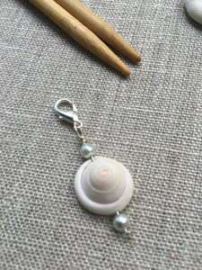 close up view of the genuine shell stitch marker with lobster clasp