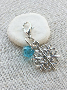 detailed closeup of silver toned stitch marker with aqua acrylic bead detail tool for knitting and crochet