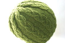 green cable knit hat pattern shown on the head of a mannequin
