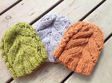 Chunky Surf City cable knit hat pattern shown in orange green and gray